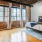 Model bedroom at our apartments for rent in Dallas, TX, featuring wood grain floor paneling and windows with curtains.