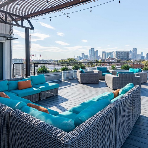 Lounge Rooftop lounge at our apartments for rent in Dallas, TX, featuring outdoor furniture and a view of the city.