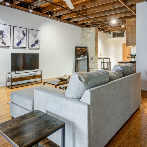 Living Room Model living room at our apartments for rent in Dallas, TX, featuring wood grain flooring and a flat screen TV.
